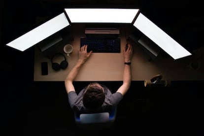 Un experto en seguridad informática trabaja frente a múltiples pantallas de ordenador