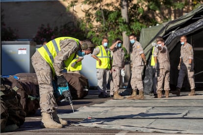 Un grupo de militares monta una carpa de triaje en el aparcamiento del Hospital Universitario de Zaragoza.