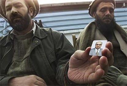 Unos amigos del ministro Abdul Rahman muestran una fotografía del fallecido en la puerta de su casa en Kabul.