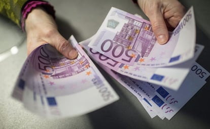 Un empleado de banca muestra billetes de 500 en una sucursal del banco Sparkasse en Múnich (Alemania).