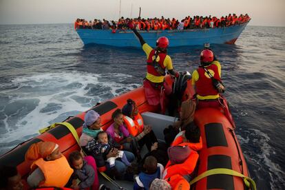 Migrantes de Eritrea abrazan a sus hijos tras ser rescatados de una barcaza de madera por la ONG Proactiva Open Arms, este lunes frente a la costa libia.