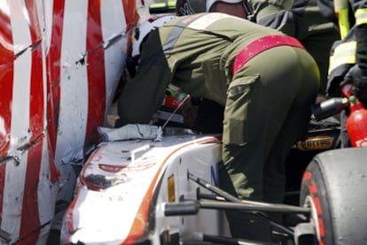 Un operario ayuda a evacuar a Sergio Pérez tras su accidente.