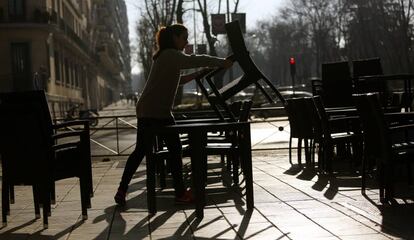 Una camarera monta una terraza en Madrid.