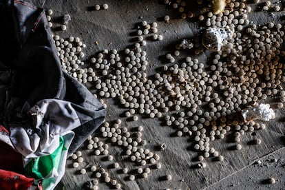 Captagon tablets on the floor of the industrial plant, next to a Syrian flag of the Assad regime.