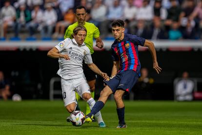 Luka Modric (a la izquierda) lucha por el balón con Pedri.