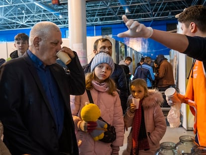 Un grupo de refugiados son guiados por un voluntario en el centro de acogida en la feria de Moldavia en la capital, Chisináu.