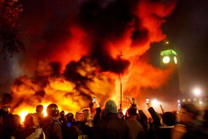 El fuego se extiende frente al Parlamento durante las protestas de ayer en Londres contra las tasas universitarias.