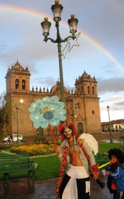 Un arcoíris gravita sobre un voluntario y un niño en la Plaza de Armas El Cuzco.