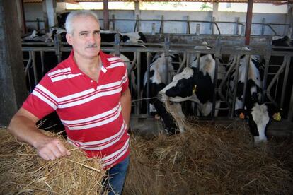 Manuel Puñal posa ante las vacas de ordeño de su granja, en el municipio coruñés de Ponteceso.