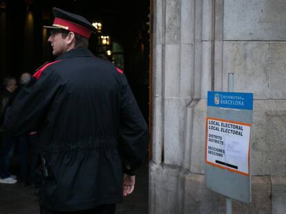 Un agente de los Mossos d'Esquadra vigila la entrada del colegio electoral este domingo.