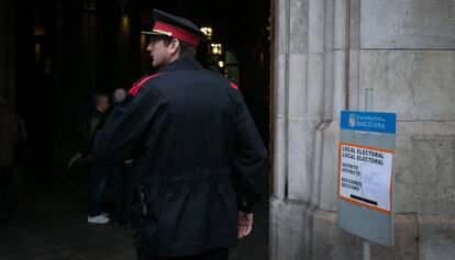 Un agente de los Mossos d'Esquadra vigila la entrada del colegio electoral este domingo.