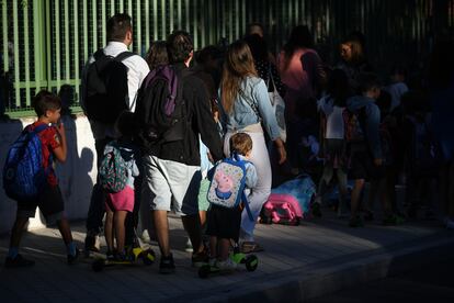 Niños y padres hacen cola para entrar al colegio el primer día en Madrid.