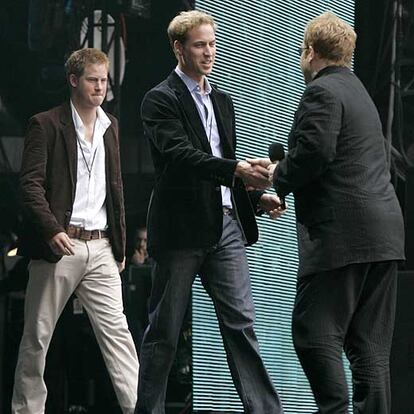 Elton John saluda a los príncipes Harry (izquierda) y William, en el concierto celebrado en memoria de Lady Di el 1 de julio de 2007.