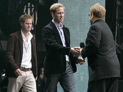 Elton John saluda a los príncipes Harry (izquierda) y William, en el concierto celebrado en memoria de Lady Di el 1 de julio de 2007.