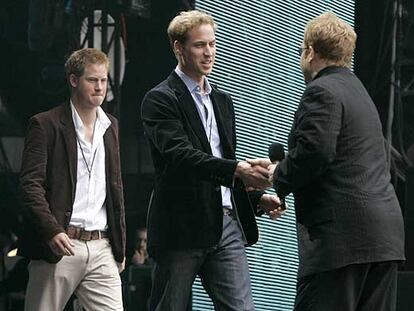 Elton John saluda a los príncipes Harry (izquierda) y William, en el concierto celebrado en memoria de Lady Di el 1 de julio de 2007.