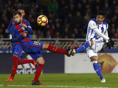 El delantero mexicano de la Real Sociedad, Carlos Vela (d), golpea el balón ante el defensa del FC Barcelona, Jordi Alba.