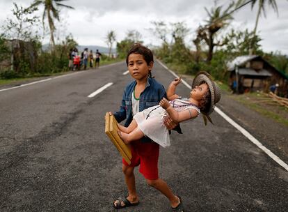 Un niño filipino sujeta una imagen religiosa en la ciudad de Milaor (Filipinas) tras el paso del tifón Nock-ten.