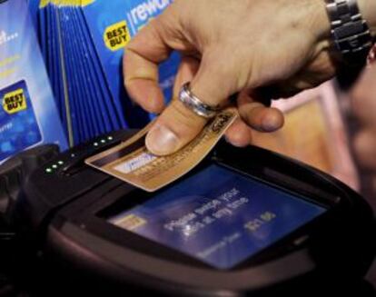Una persona usa su tarjeta de crédito para hacer compras