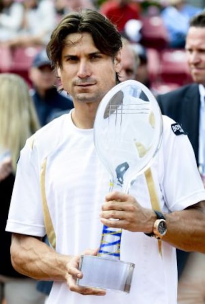 Spain&#039;s David Ferrer holds the trophy after winning the men&#039;s single final against compatriot Nicol&aacute;s Almagro.