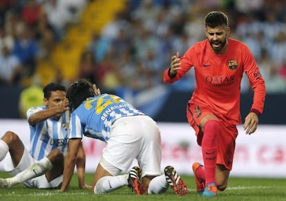 Gerard Piqué se lamenta tras una ocasión fallida ante los defensas del Málaga Sergio Sánchez y Weligton.