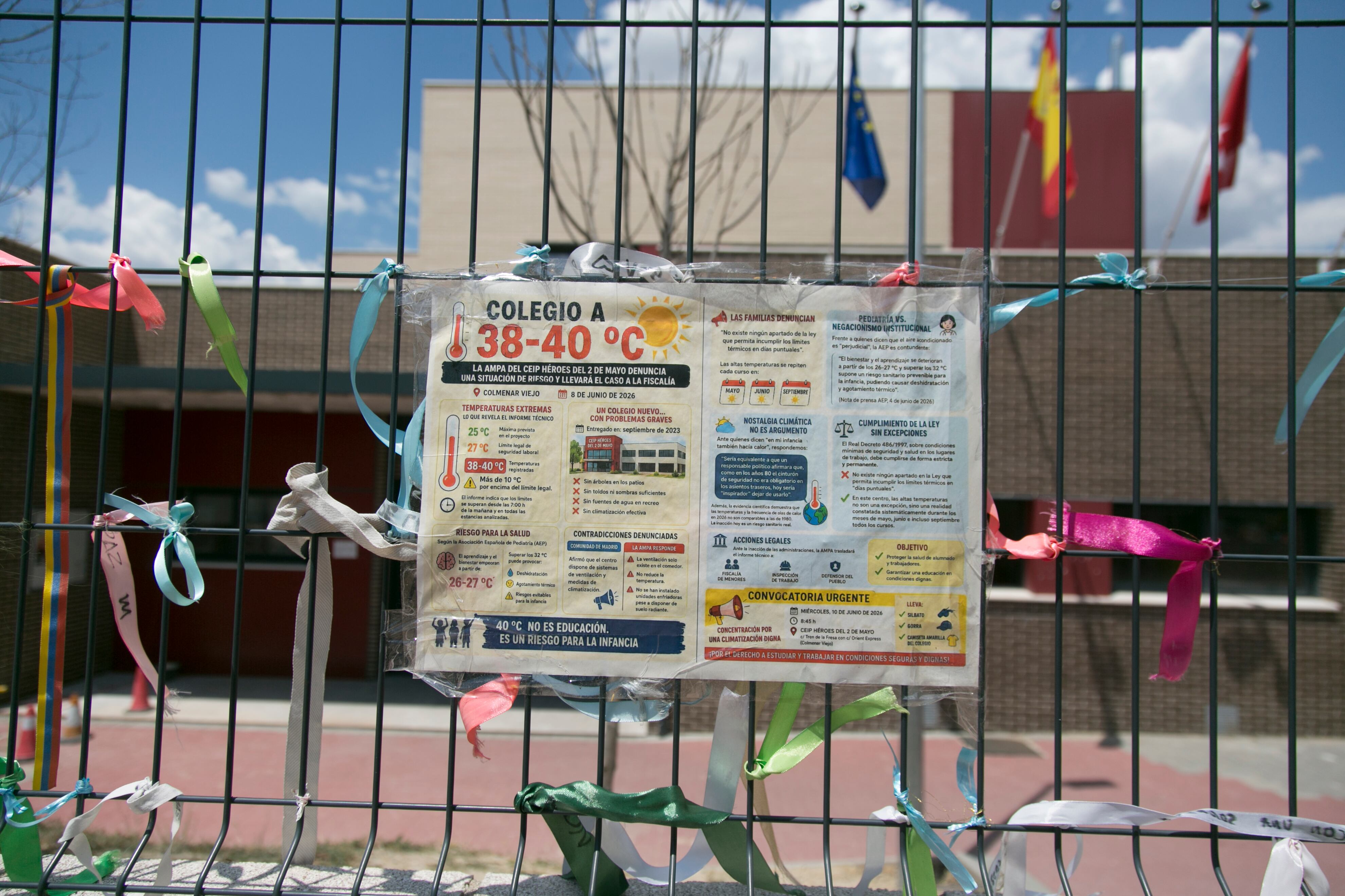 Cartel sobre las altas temperaturas en el vallado del colegio Héroes del Dos de Mayo, en Colmenar Viejo.