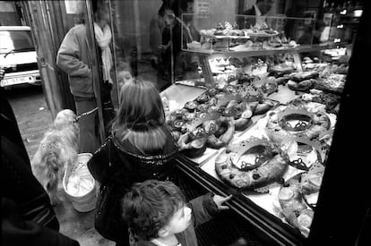 Unos niños observan el mostrador de una pastelería del centro de Barcelona donde predomina el roscón de Reyes