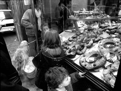 Unos niños observan el mostrador de una pastelería del centro de Barcelona donde predomina el roscón de Reyes