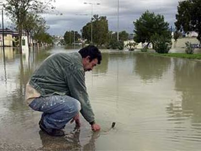 Un trabajador intenta desatascar un desagüe en una calle del polígono El Portal, en Jerez.