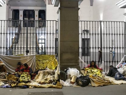 Un grupo de solicitantes de asilo se dispone a pasar la noche frente a la sede del Samur Social, en el centro de Madrid.