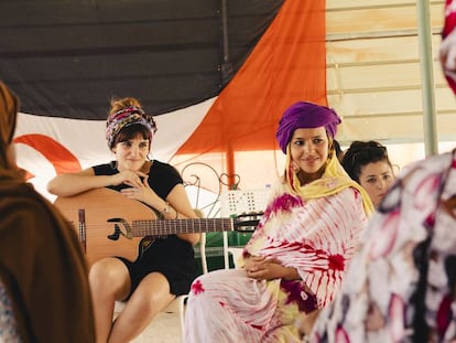 Rozalén, con la guitarra, escucha a mujeres saharauis. 