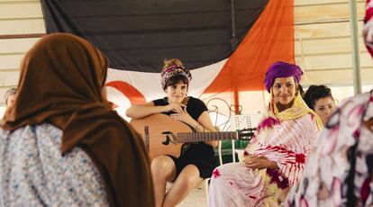 Rozalén, con la guitarra, escucha a mujeres saharauis.