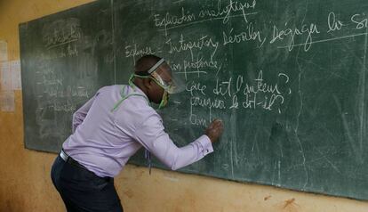 Un profesor da clase, con un sistema de protección, en un aula de Camerún.  