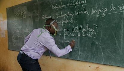 Un profesor da clase, con un sistema de protección, en un aula de Camerún.