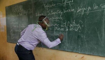 Un profesor da clase, con un sistema de protección, en un aula de Camerún.  