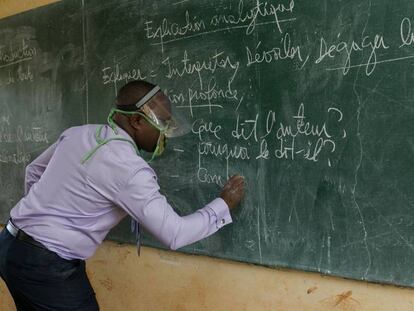 Un profesor da clase, con un sistema de protección, en un aula de Camerún.  