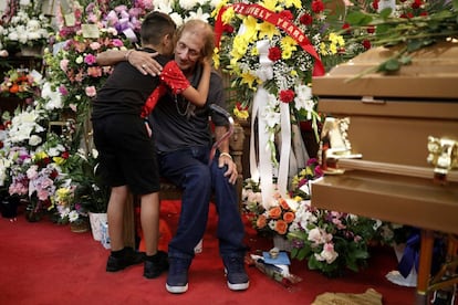 Cualquier persona sería "bienvenida” en la ceremonia, comentó Antonio Basco. Temía enterrar a su mujer “solo”, ha declarado el director de la funeraria, Harrison Johnson. “Esta es una comunidad que se ha congregado para acompañarlo, para sostenerlo”, recoge el diario 'The New York Times'. Margie fue su “primer amor”, afirmó Basco en el diario 'El Paso'. En la imagen, el viudo se abraza a un niño junto al ataúd de su esposa.