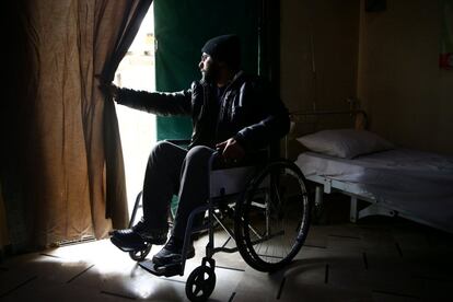 Haitham, de 35 años, parapléjico debido a una lesión de médula espinal que sufrió dutante el conflicto sirio, mira por una puerta del centro de rehabilitación de Douma, en Damasco (Siria).