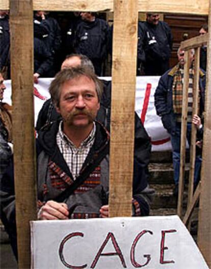 José Bové protesta en una jaula de madera ante los juzgados de Millau.
