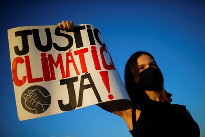 Ativista mostra cartaz pedindo justiça climática durante manifestação em Brasília, em setembro de 2020.