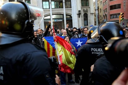 Policías antidisturbios controlan a un grupo de manifestantes en Vía Laietana (Barcelona). Los agentes de los Mossos d'Esquadra han desmontado una barricada que los manifestantes de los CDR habían montado en la avenida Paral·lel de Barcelona, el punto de mayor tensión de las protestas convocadas contra el Consejo de Ministros, cruzando contenedores y vallas metálicas.