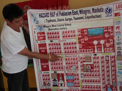 El líder del 'barangay' de Poblacion East, Joseleo O. Tan, muestra el plan de evacuación de la zona, en Milagros (Filipinas).