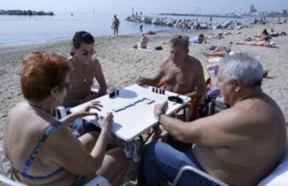 En la imagen un grupo de jubilados juegan al dominó en la playa de la Barceloneta. EFE/Archivo