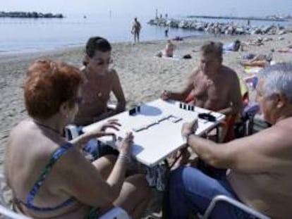 En la imagen un grupo de jubilados juegan al dominó en la playa de la Barceloneta. EFE/Archivo