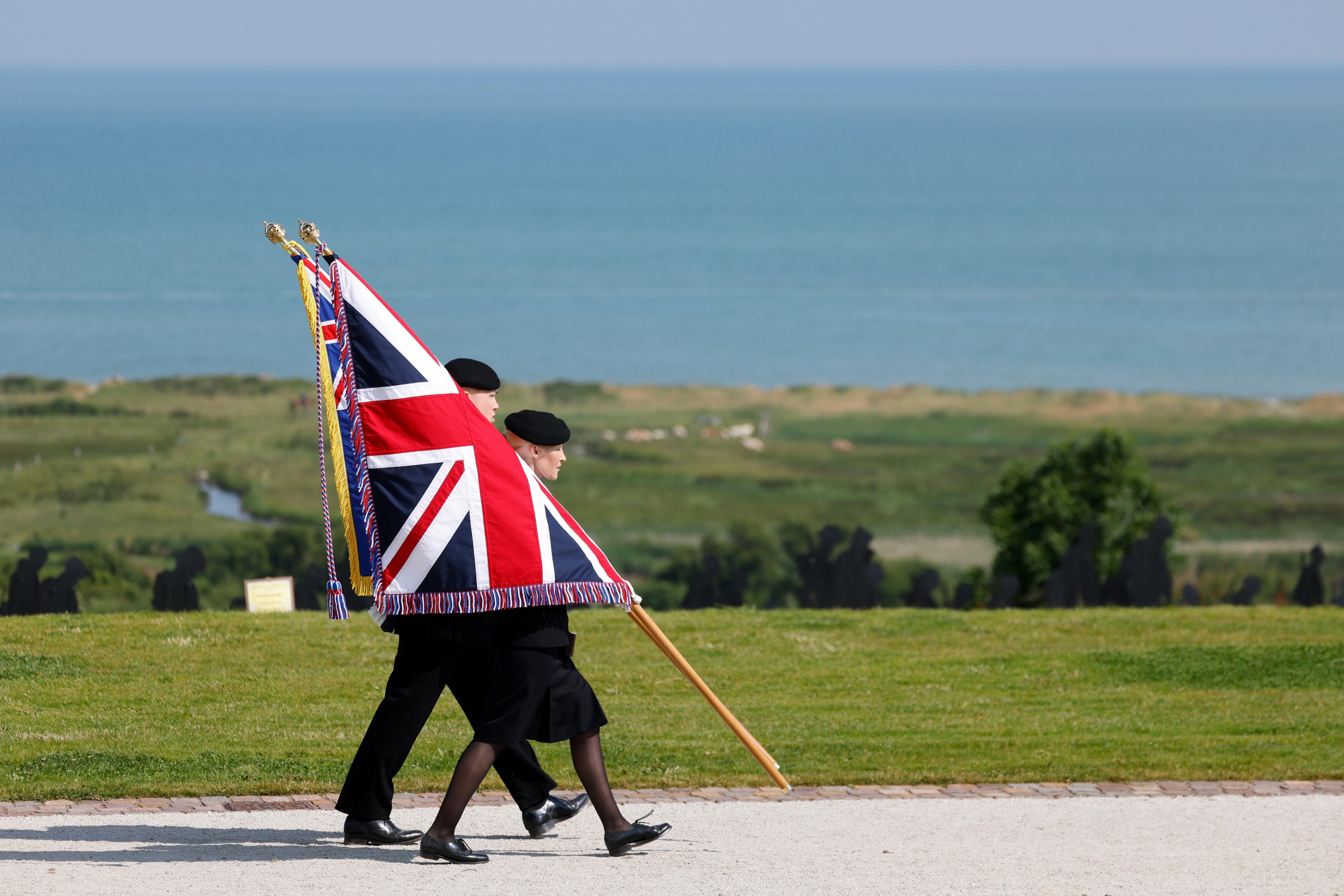 Dos jóvenes sostienen la bandera de la Union Jack durante la ceremonia conmemorativa a cargo del Ministerio de Defensa del Reino Unido y de la Legión Real Británica en el Memorial de la Normandía Británica, cerca del pueblo francés de Ver-sur-Mer.