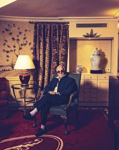 Por edad, Charles Aznavour casi podría ser el primo del jarrón de la dinastía Ming que tiene detrás y el abuelo de las cortinas que decoran esta estancia.