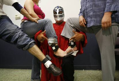 Un luchador posa con inmigrantes indocumentados que llevan los grilletes GPS.