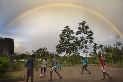 Unos niños jugando a fútbol bajo el arcoiris en un descampado de la Nueva Bellavista apenas dejó de llover, cosa habitual en esta región que se considera la segunda más pluviosa del mundo.  
