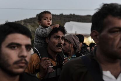 Un hombre lleva a su hijo a hombros durante una protesta de refugiados en el centro de detención de Moria, en la isla de Lesbos.