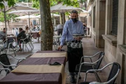 Un camarero recoge una mesa en la terraza de su restaurante, en Orense.