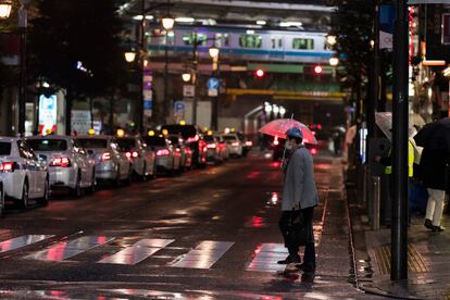 Un hombre camina por una intersección hacia una estación de tren en Tokio el pasado marzo.